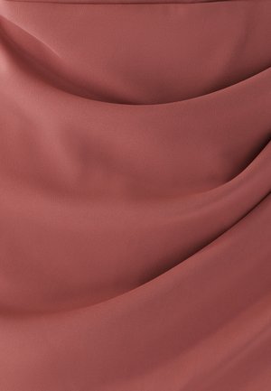 Tissu doux et froncé de couleur rose poussiéreux avec des plis lisses et un léger éclat, mettant en valeur la texture et le tombé du matériau.
