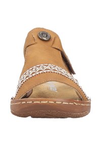 Brown leather sandal with a braided white strap, adjustable buckle, and textured insole. Flat sole with stitching details and a rounded toe.