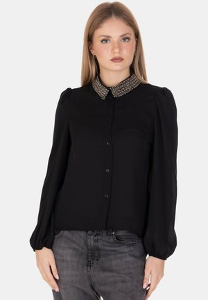 Blusa nera con maniche lunghe e design a sbuffo. Presenta un collare di perline luccicanti e una chiusura frontale con bottoni, realizzata in un tessuto morbido.