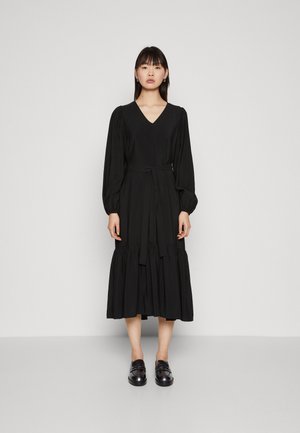 Black midi dress with long puff sleeves, v-neckline, cinched waist, and tiered skirt. Smooth, lightweight fabric and a belted detail.