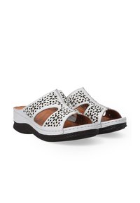 Witte open-toe sandalen met ingewikkelde uitsnijdingen; bruine binnenzolen en patronen op de zolen zorgen voor een comfortabele, casual schoenoptie.