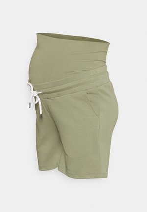 Calças de maternidade em algodão misto verde-oliva, com uma cinta elástica larga, fecho de cordão e bolsos laterais. Textura suave.