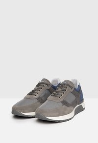 Sneaker in camoscio grigio e rete con accenti blu navy, punta rotonda, chiusura con lacci e suola bianca imbottita. Parte superiore testurizzata e dettagli perforati.