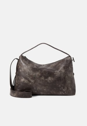 Sac à main en cuir marron foncé texturé avec une bandoulière simple et une bandoulière plus longue amovible, fermeture éclair et nom de marque embossé discret à l'avant.