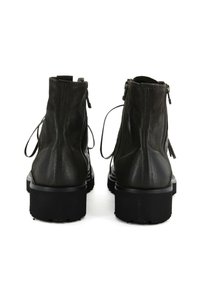 Stivaletti neri in pelle liscia con una texture morbida, dotati di una suola spessa, zip sui lati e dettagli in pizzo sul retro.