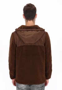 Chaqueta de forro polar marrón con capucha de nylon marrón en contraste, que presenta una textura suave y un ajuste relajado. El diseño incluye un color sólido sin patrones.