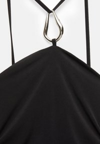 Haut en tissu noir de forme triangulaire avec des bretelles fines, présentant un détail en métal argenté au niveau du col. Texture lisse.