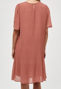 Hladké, šaty až ke kolenům v jemné růžové barvě; mají krátké rukávy, uzavření na klíčovou dírku na zádech a rozšířený lem.