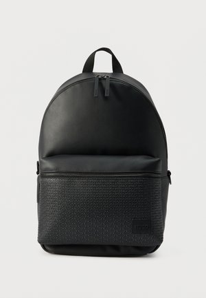 Zaino nero con parte superiore arrotondata, tasca frontale con cerniera, impressa con il testo ripetuto "HUGO", e doppia cerniera sul compartimento principale.