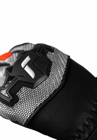 Texturierter schwarzer Lederhandschuh mit einem silbernen, gewebten Muster und einem schwarzen Kunststoffakzent mit einem Logo. Beinhaltet rote Details in der Nähe des Handgelenks.