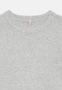 Prim-plan al unei cămăși din tricot gri, cu guler rotund, cu o etichetă de țesătură vizibilă în interiorul gulerului.