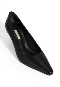 Zwarte leren pump met een puntige neus, een gladde textuur, een laag uitgesneden ontwerp en een minimalistische stijl. Voorzien van een subtiele binnenvoering.