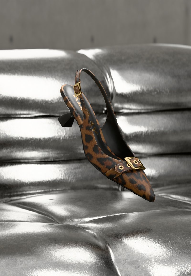 Γυναικείο παπούτσι slingback με λεοπάρ σχέδιο, μυτερή μύτη, χρυσές μεταλλικές λεπτομέρειες και μικρό τακούνι, τοποθετημένο πάνω σε λαμπερή μεταλλική επιφάνεια.