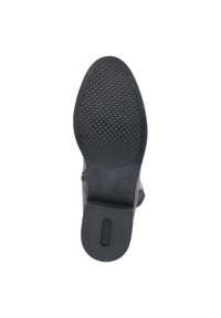Semelle de chaussure noire avec un motif de traction texturé, présentant une finition lisse et une forme arrondie. Accentuée d'un logo au niveau du talon.