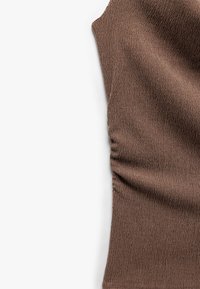 Top marrone senza maniche in tessuto texturizzato con dettaglio arricciato su un lato; finitura liscia e motivo sottile in tutta la superficie.