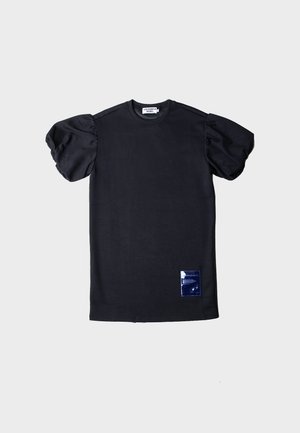 Fekete rövid ujjú póló felfújt ujjakkal, kerek nyakkal és kék folt részlettel az alsó elején. Lágy pamut anyagból készült.