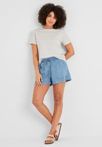 Light grey speckled t-shirt, loose fit; blue cotton shorts with elastic waistband and drawstring; sandals with two adjustable straps.
