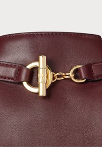 Bordowa skórzana torebka z zapięciem w kolorze złotym i łańcuszkowym wykończeniem. Gładka tekstura z wyrafinowaną konstrukcją.