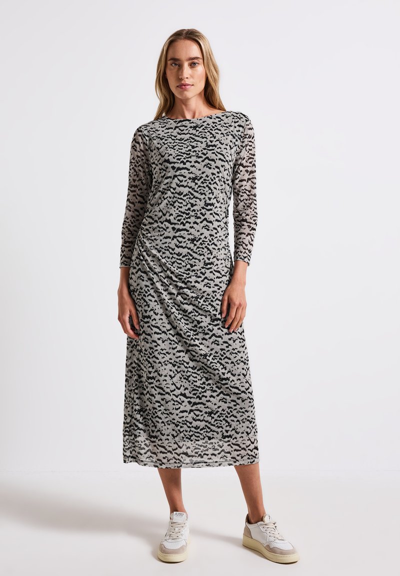 Langes, körperbetontes Kleid aus einem durchsichtigen, leichten Stoff mit einem abstrakten Muster in Schwarz und Grau, runder Halsausschnitt und langen Ärmeln.