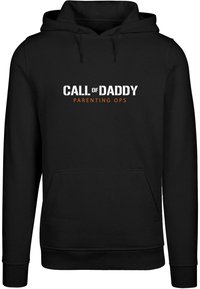 Sudadera con capucha negra que presenta un bolsillo frontal. El texto centrado dice "CALL of DADDY" en blanco, con "PARENTING OPS" en naranja debajo.