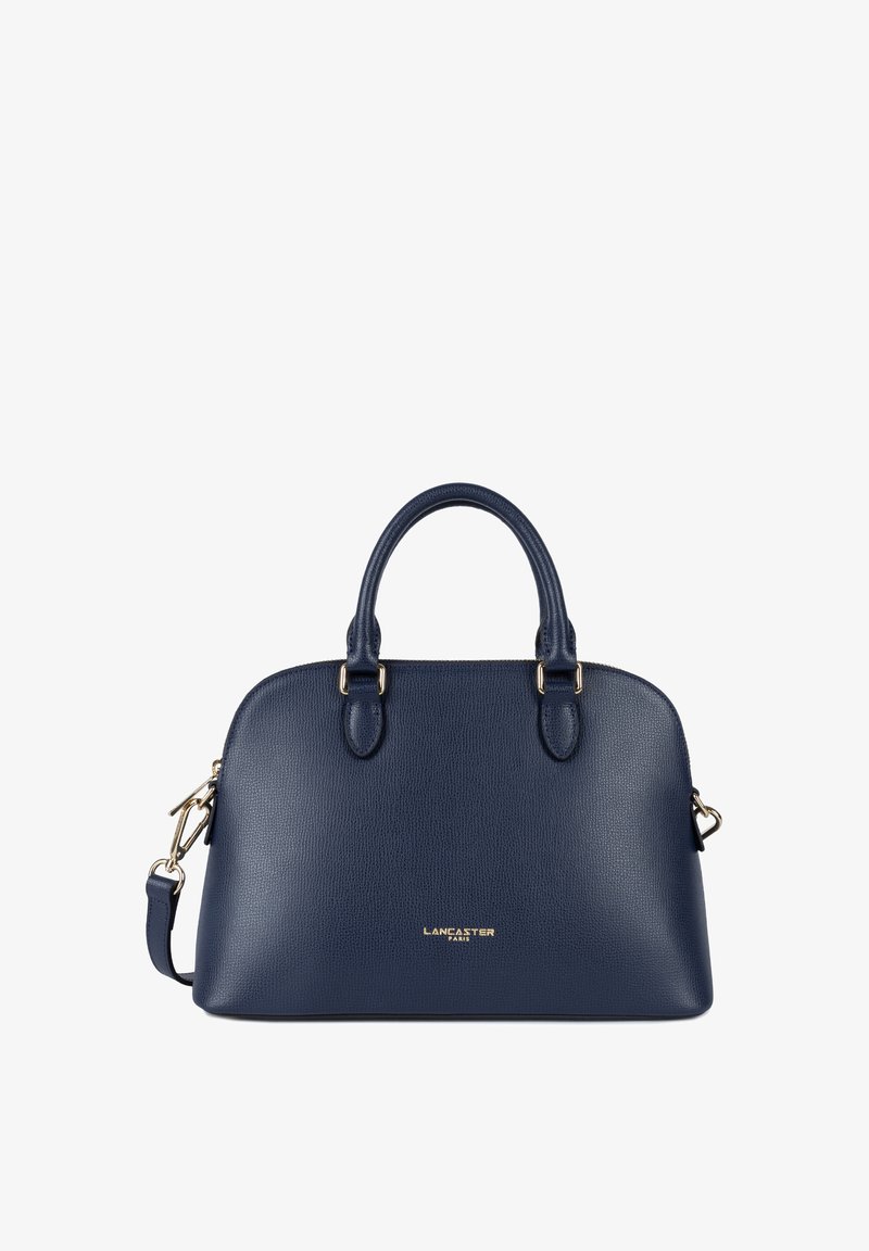 Sac à main en cuir bleu marine avec des accessoires dorés, forme structurée, doubles poignées supérieures et une bandoulière amovible. Présente un logo sur le devant.