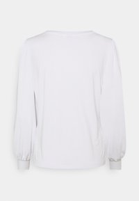 Vit långärmad skjorta med rund halsringning och puffärmar. Mjukt tyg med en slät textur. Inga synliga mönster eller detaljer i hårdvara.