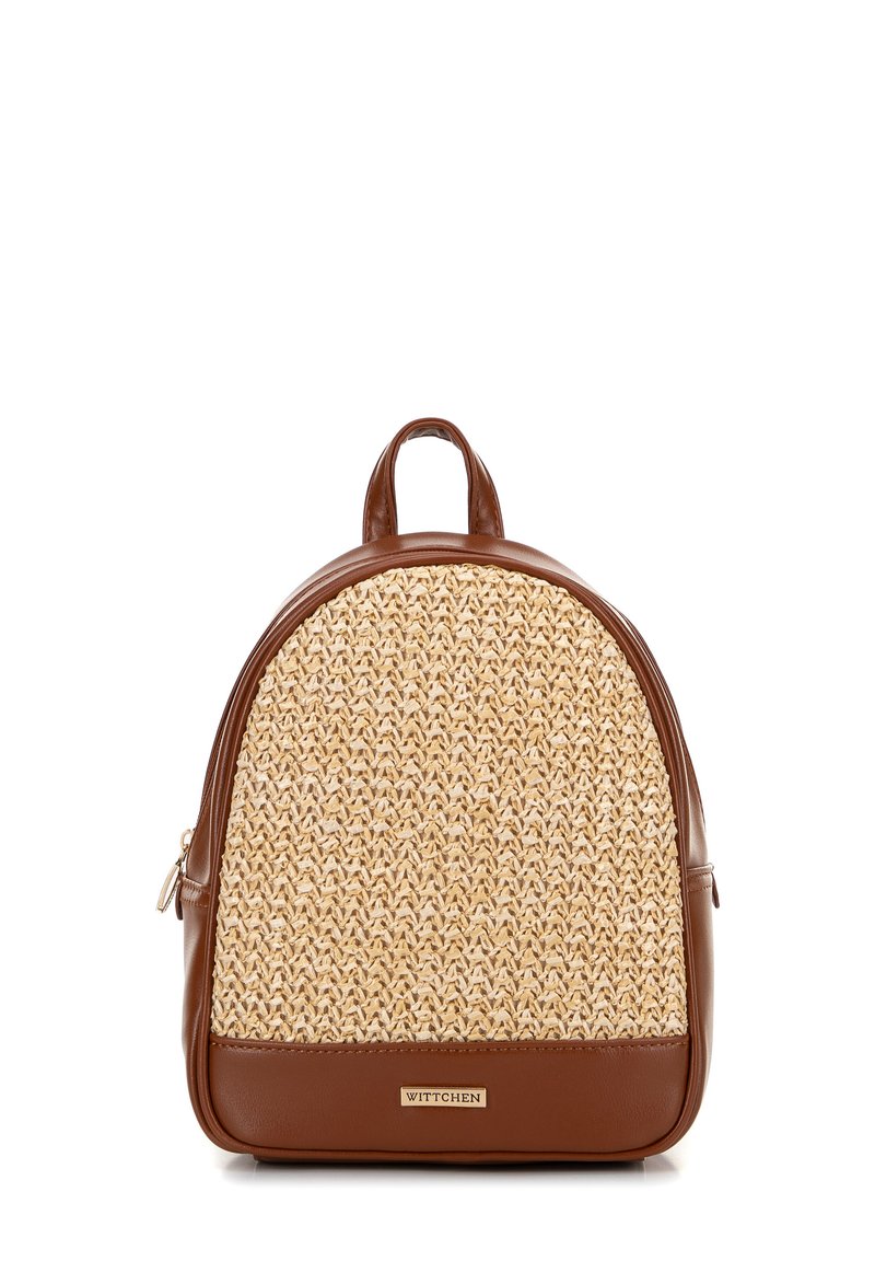 Mochila de cuero marrón y paja trenzada con forma redondeada, con un asa superior y una pequeña etiqueta de marca en la parte inferior.