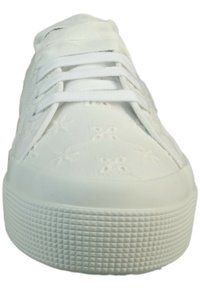 Zapatilla de lona blanca con patrón floral bordado, suela de goma plana y cordones blancos. Textura suave y diseño de punta redonda.