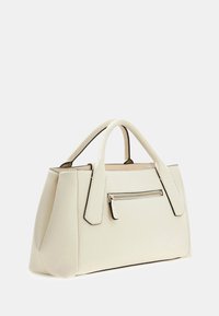 Sac à main crème au design structuré, avec des poignées arrondies et une poche zippée à l'avant. Fabriqué en simili cuir texturé avec des accents noirs.