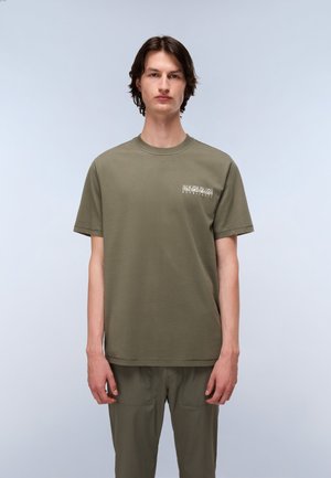 Olivenfarvet bomulds-T-shirt med korte ærmer og rund hals. Har et lille trykt design på venstre bryst. Glat tekstur.