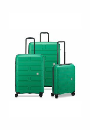 Three green, hard-shell suitcases of varying sizes feature a textured design with horizontal grooves, retractable handles, and four wheels each.