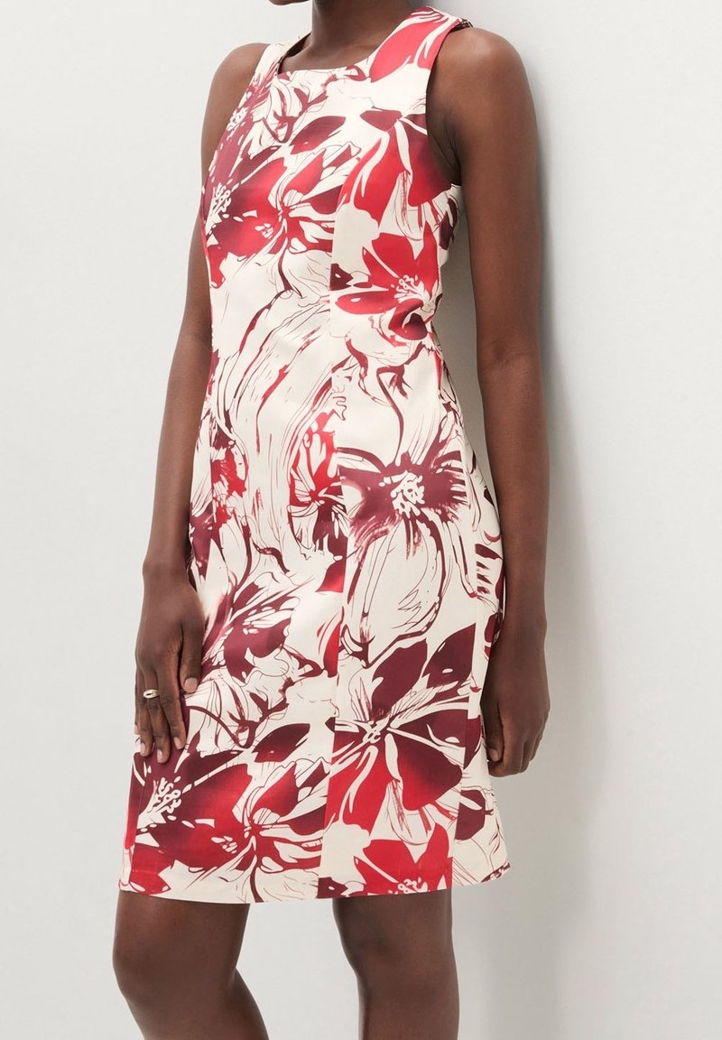 Robe florale avec des couleurs rouge et crème, design ajusté, sans manches et longueur au genou. Présente de grands motifs floraux et une texture lisse.