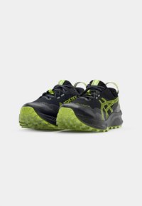 Black and neon green trail running shoes feature a breathable upper, textured outsole, and reflective accents for visibility and grip.