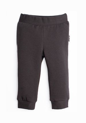 Czarne spodnie dla malucha z elastyczną talią, ściągaczami przy nogawkach i małą boczną metką na białym tle.