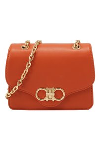 Borsa a tracolla in pelle arancione con una catena dorata, caratterizzata da una pattina curvata e una chiusura decorativa dorata sul fronte. Texture liscia.