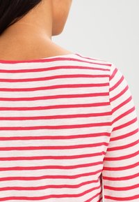 Maglione a righe con strisce orizzontali rosse e bianche, morbido in maglia, con scollatura rotonda e vestibilità comoda.