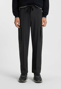 Black, lightweight trousers with a relaxed fit, featuring side pockets and a drawstring waistband. Smooth texture, suitable for casual wear.