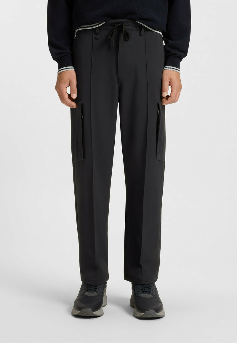 Black, lightweight trousers with a relaxed fit, featuring side pockets and a drawstring waistband. Smooth texture, suitable for casual wear.