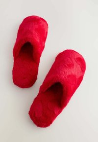 Røde, fluffy slippers med hjerte mønstre, åben tå design og en blød tekstur. Rundet form og tykke såler for komfort.