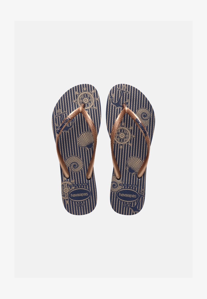 Chanclas azules con tiras doradas, decoradas con iconos de temática náutica como anclas, conchas y timones, etiquetadas como "havaianas".