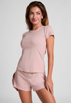 Lichtroze, gebreide top met korte mouwen en subtiele ribbeltextuur, met bijpassende shorts. Minimalistisch ontwerp zonder zichtbare hardware of accenten.