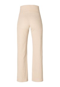 Beżowe dzianinowe spodnie z wysokim stanem i szerokimi nogawkami. Teksturowany materiał w prążki sięga kostek.