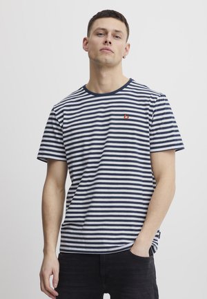Navy and white striped t-shirt in cotton fabric, crew neck with ribbed trim, featuring a small red logo on the chest. Short sleeves, relaxed fit.