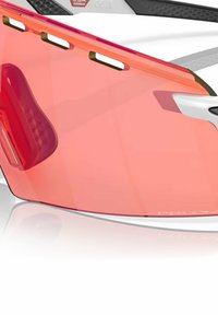 Occhiali da sole con una grande lente curva di un vivace rosso, dotata di fori di ventilazione; una montatura bianca e accenti laterali texturizzati per una migliore presa.