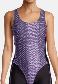 Maillot de bain avec un motif géométrique en nid d'abeille dans des nuances de violet, avec des panneaux latéraux noirs et des accents violets contrastants.