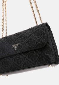 Schwarze gestepptes Handtasche mit einem auffälligen Logo, goldenen Kettenakzenten und einem Klappenverschluss. Texturierte Oberfläche mit einem eleganten Design.