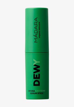 Conteneur cylindrique vert avec texte noir "MADARA organic skincare" et "DEWY Hydra Caffeine Serum Stick" sur le devant.
