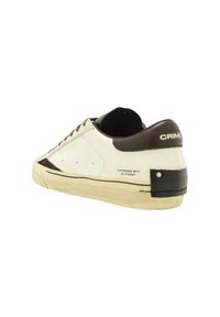 Sneaker in pelle bianca con tallone in pelle marrone, dettagli in stile invecchiato, accenti neri e suola in gomma. Presenta dettagli di branding e cuciture.