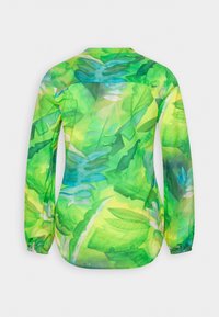 Chemise à manches longues avec poignets élastiques arborant un motif de feuilles tropicales vertes vives avec des accents bleus et jaunes.