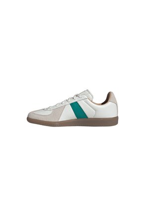 Hvid lædersneaker med beige ruskind detaljer, grøn side stribe og brun gummisål, vist i sideprofil.